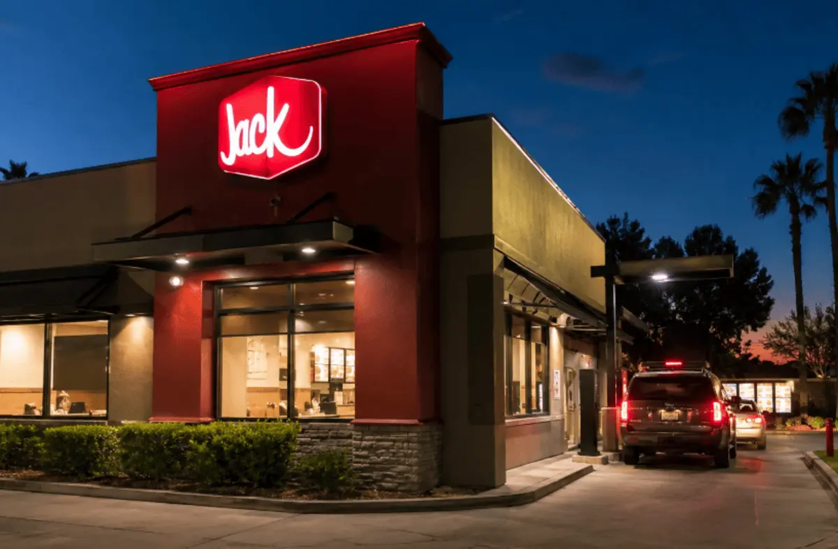Jack in the Box restaurant at night with drive-thru lane and illuminated signage showing late-night service hours concept
